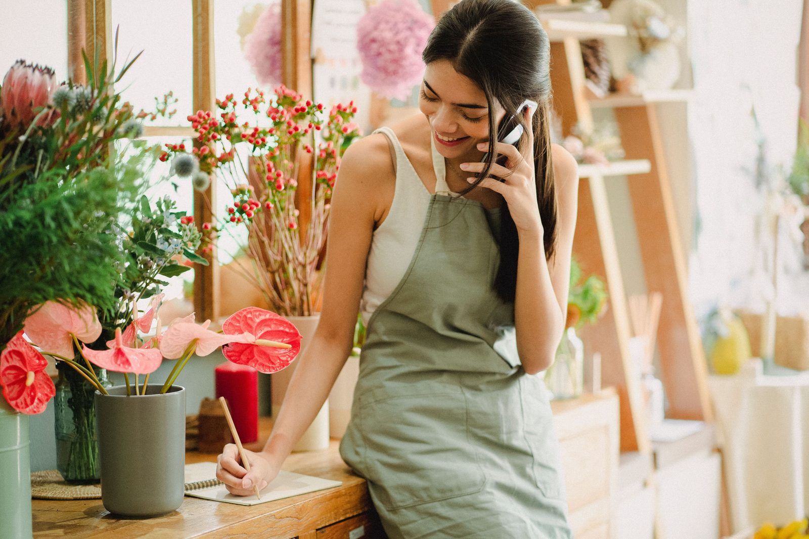 Empreendedora de pequeno negócio usando celular para atender cliente