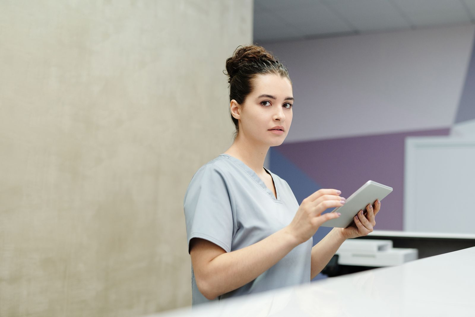 Recepcionista usa um tablet para atender cliente em uma pequena empresa de serviços