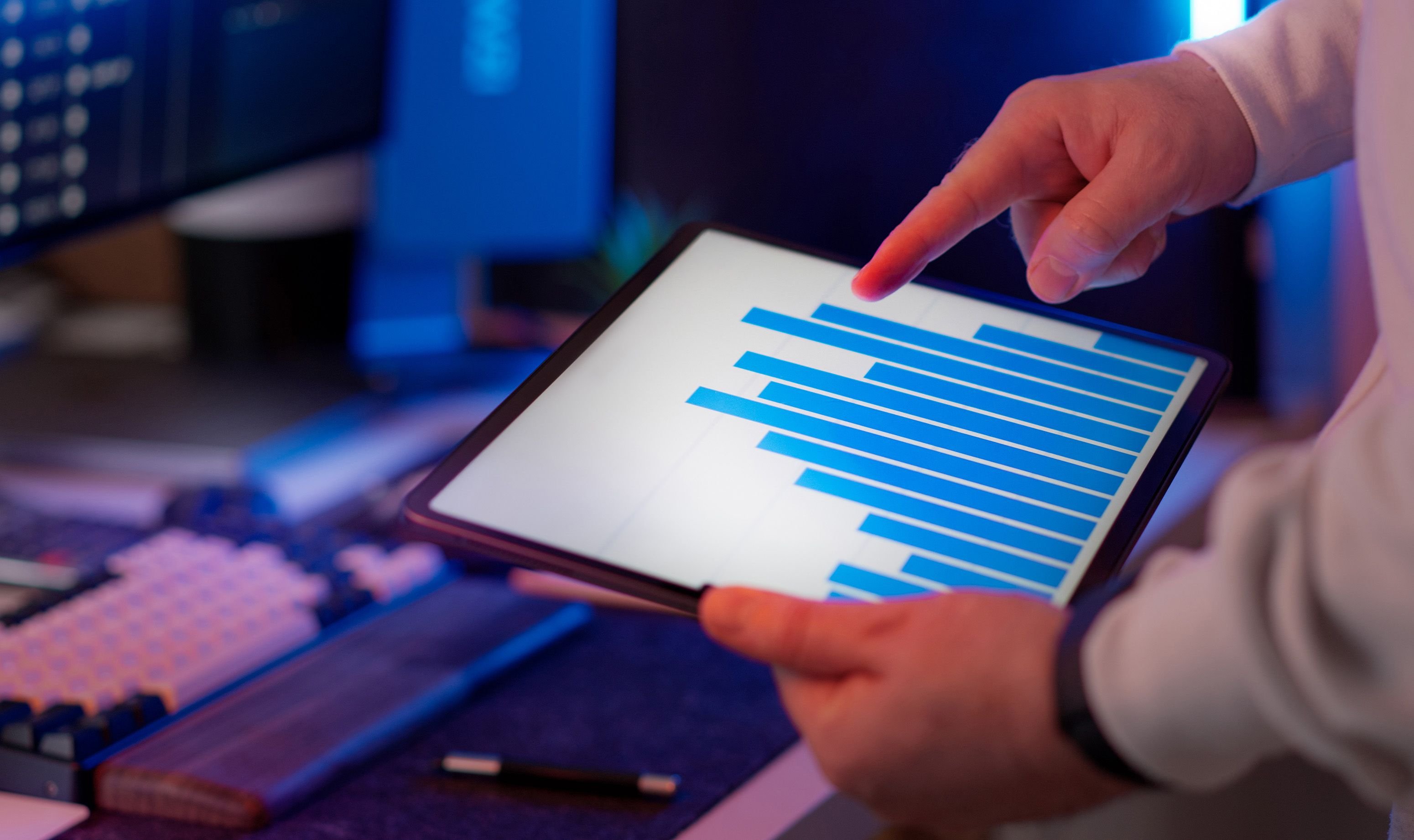 Profissional analisando gráfico de dados em tablet, representando decisão apoiada em dado