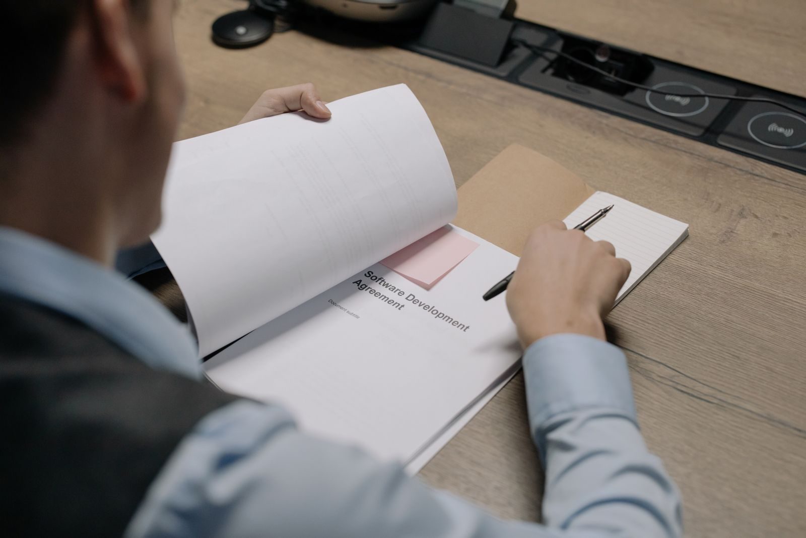 Profissional avalia um contrato de sistema de software sobre a mesa antes de assinar